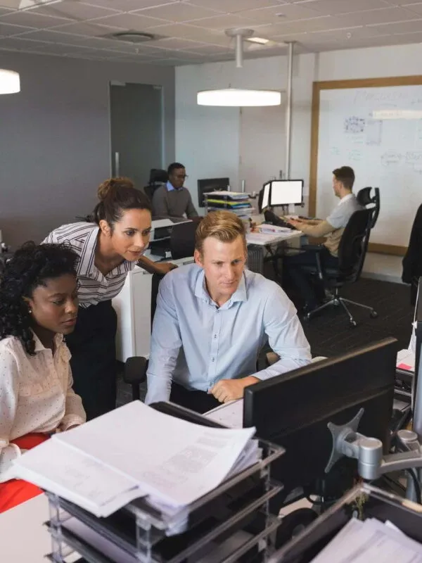 Business colleagues looking at desktop monitor in office