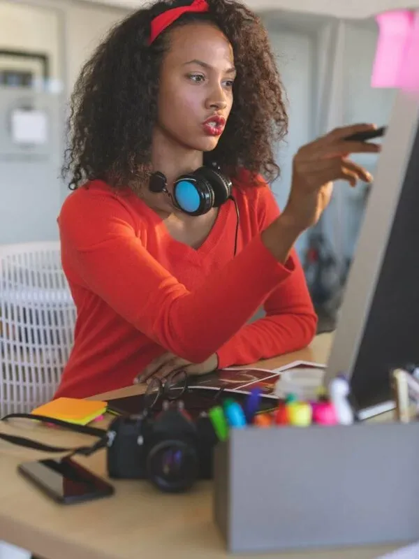 Female graphic designer working on desktop pc at desk