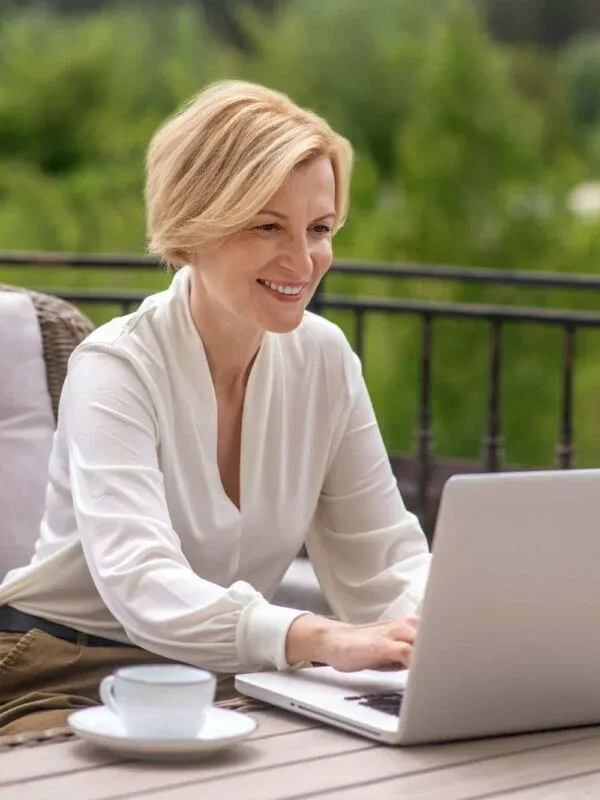 Joyful woman writing an email on the notebook computer